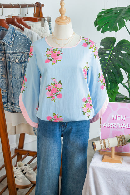 Blusa de manga 3/4 con cuello redondo, botones en los puños y estampado floral azul cielo