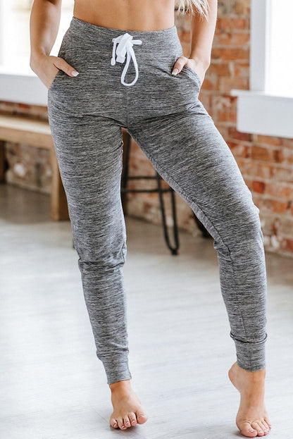 Pantalones deportivos grises con cordón, cintura elástica y bolsillos