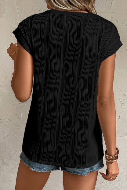 Camiseta negra con textura ondulada y botones en cuello de pico