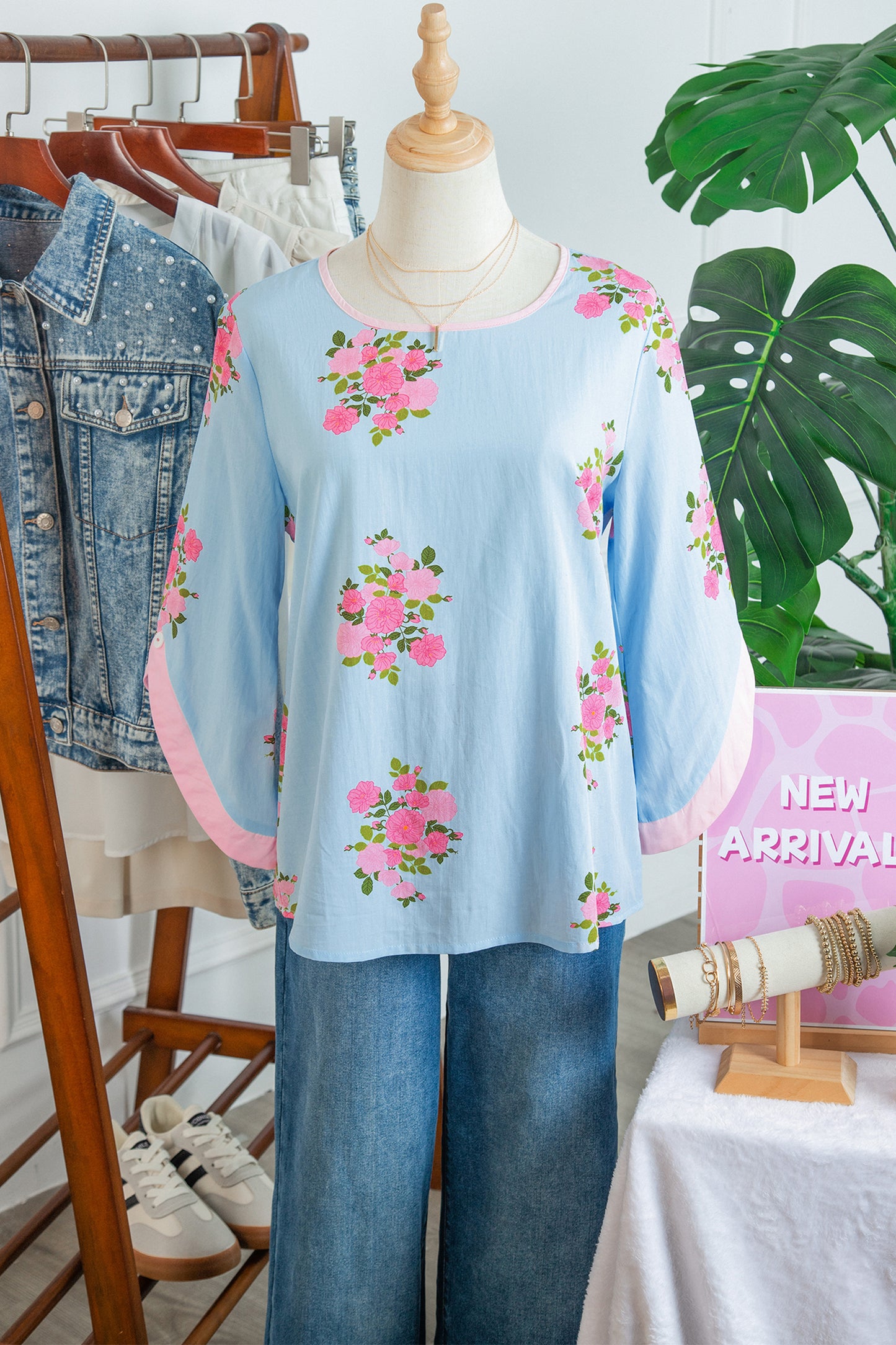Blusa de manga 3/4 con cuello redondo, botones en los puños y estampado floral azul cielo