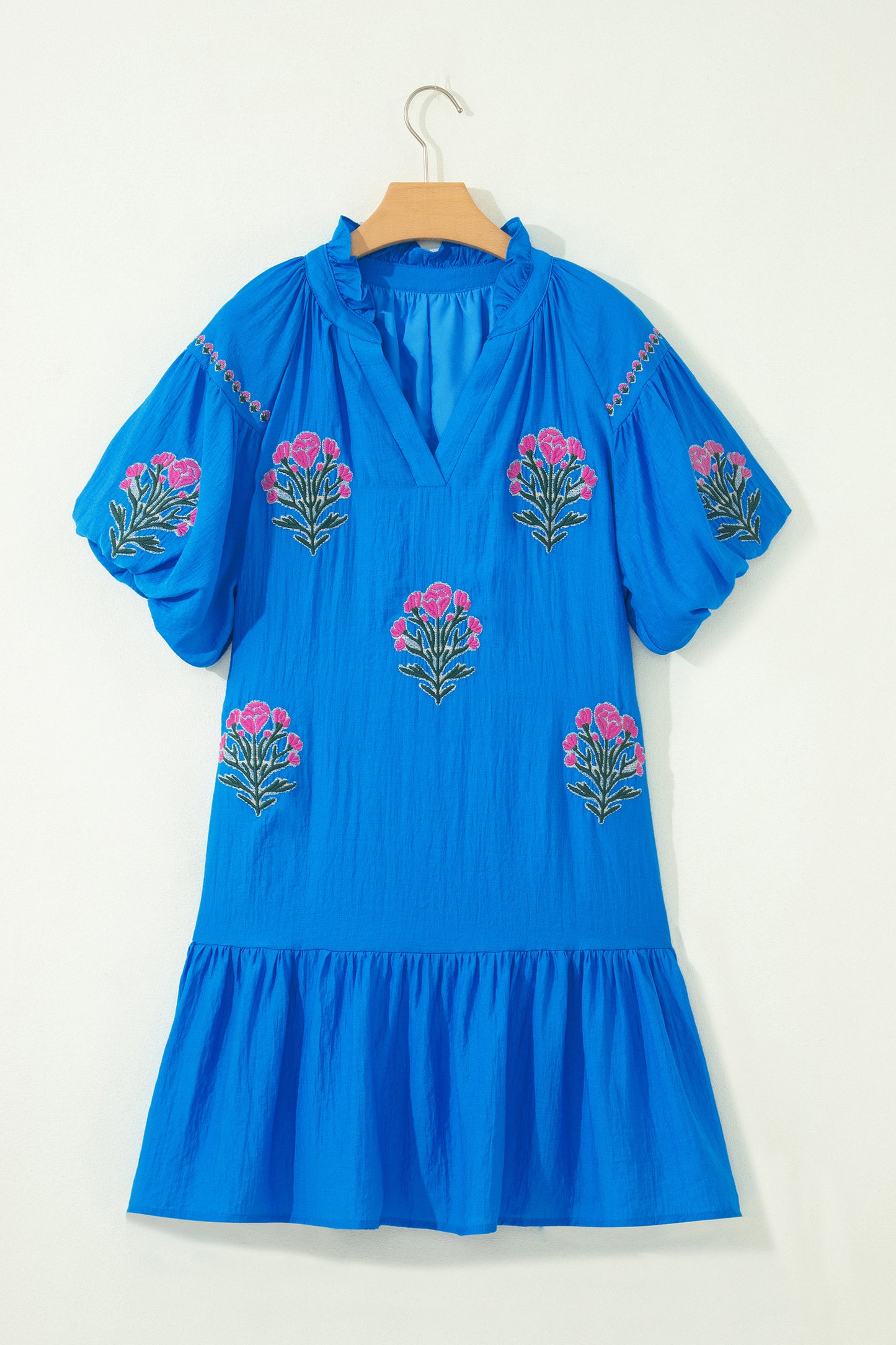 Vestido con bordado de flores azules, cuello dividido, mangas cortas abullonadas y dobladillo con volantes