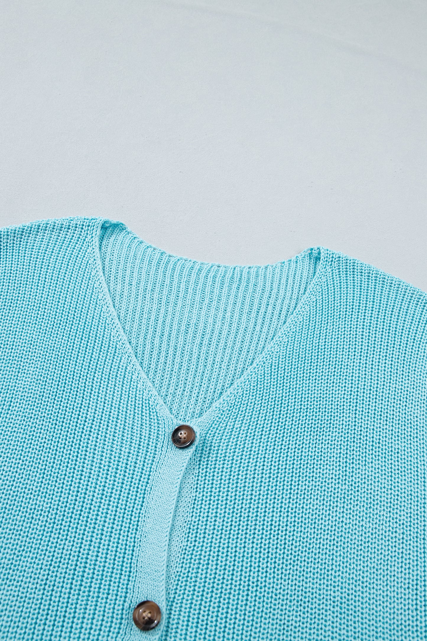 Chaleco de punto en color azul niebla con cuello de pico y botones delanteros