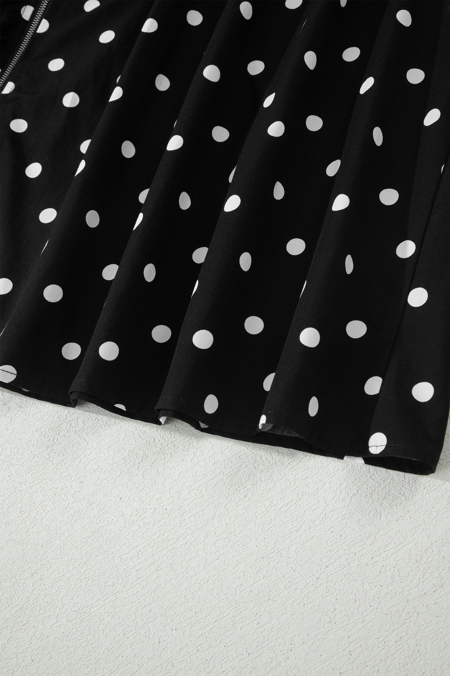 Vestido sin mangas con cremallera, cuello en V, ribete en contraste y estampado de lunares negros