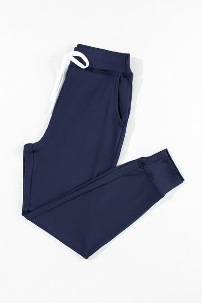 Pantalones deportivos azul marino con cordón ajustable en la cintura elástica y bolsillos