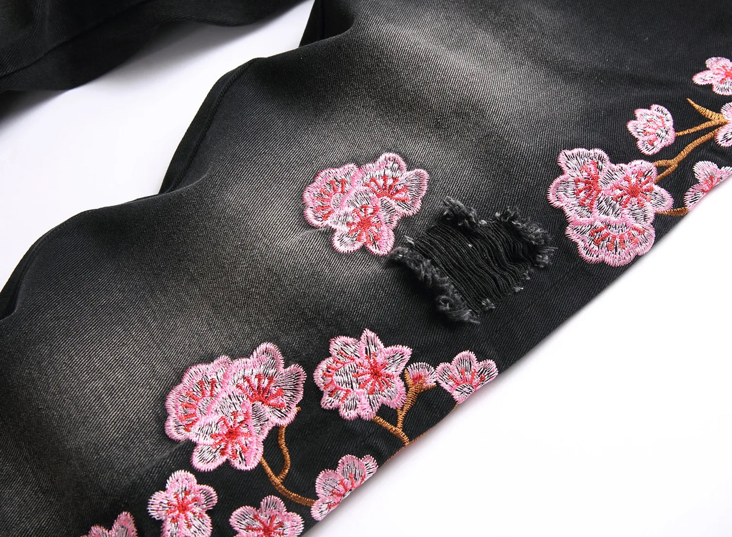 Vaqueros rotos de hombre de moda con parches de bordado floral, vaqueros acampanados desgastados de estilo urbano de tendencia