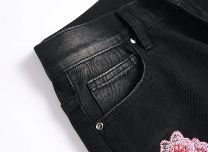 Vaqueros rotos de hombre de moda con parches de bordado floral, vaqueros acampanados desgastados de estilo urbano de tendencia