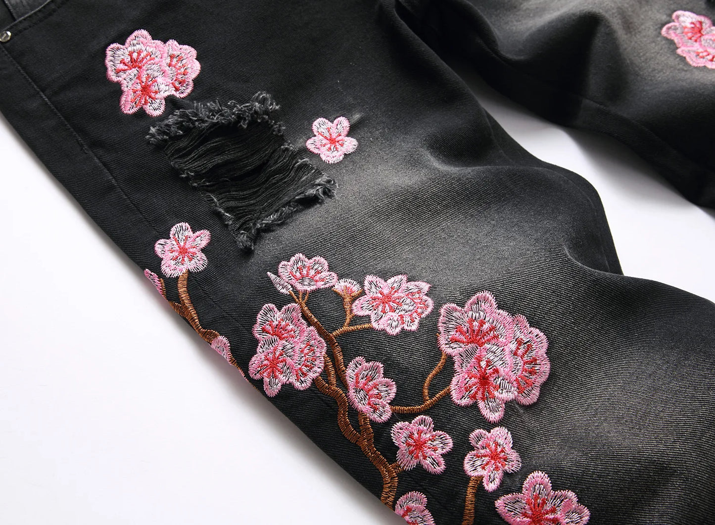 Vaqueros rotos de hombre de moda con parches de bordado floral, vaqueros acampanados desgastados de estilo urbano de tendencia