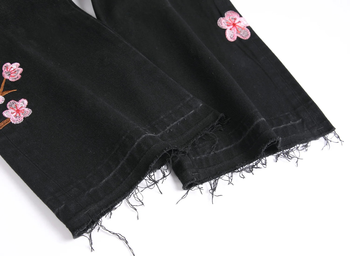 Vaqueros rotos de hombre de moda con parches de bordado floral, vaqueros acampanados desgastados de estilo urbano de tendencia