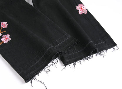 Vaqueros rotos de hombre de moda con parches de bordado floral, vaqueros acampanados desgastados de estilo urbano de tendencia