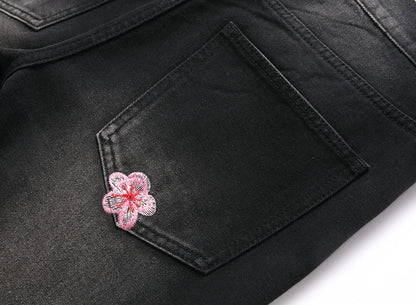 Vaqueros rotos de hombre de moda con parches de bordado floral, vaqueros acampanados desgastados de estilo urbano de tendencia