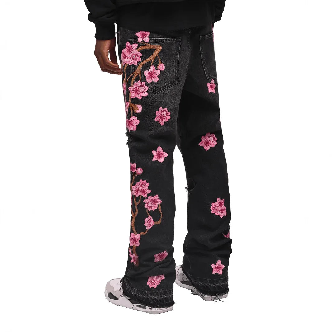 Vaqueros rotos de hombre de moda con parches de bordado floral, vaqueros acampanados desgastados de estilo urbano de tendencia