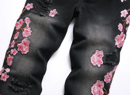 Vaqueros rotos de hombre de moda con parches de bordado floral, vaqueros acampanados desgastados de estilo urbano de tendencia