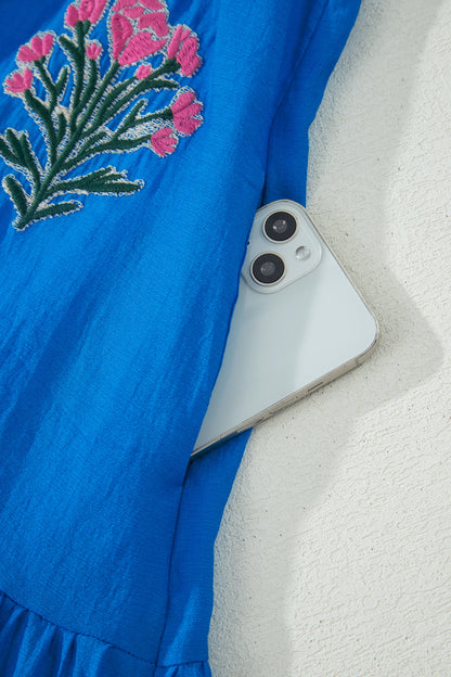 Vestido con bordado de flores azules, cuello dividido, mangas cortas abullonadas y dobladillo con volantes