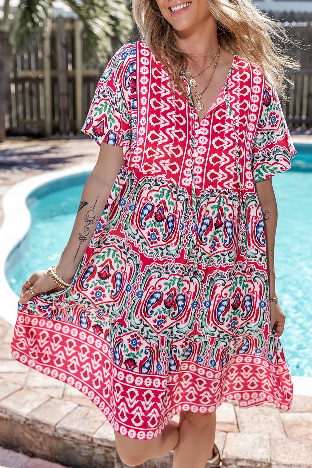Vestido corto rosa con estampado bohemio, cuello anudado y bajo con volantes