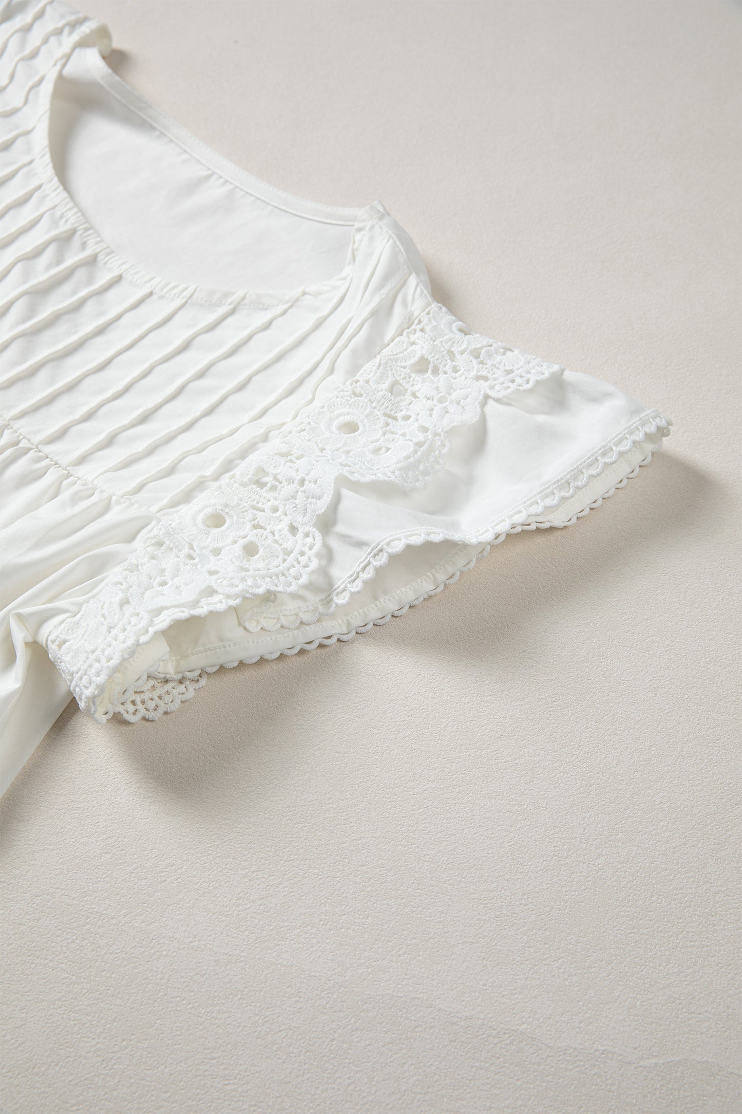 Blusa con detalle de encaje blanco, manga con volantes y cuello redondo plisado